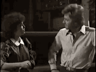 a man and a woman are standing next to each other in a room .