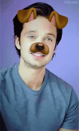 a man wearing a blue shirt with a dog 's nose on his face