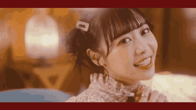 a girl with a clip in her hair is smiling
