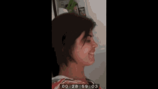 a woman is smiling and covering her mouth with her hand and the time is 13:36