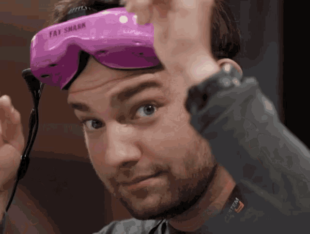 a man is wearing a purple fat shark headset