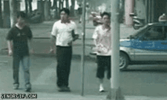 a group of people are walking down a street with a car in the background