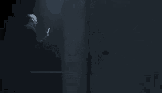 two men are standing next to each other in the dark .