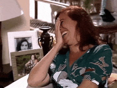 a woman covering her face with her hand in front of a picture