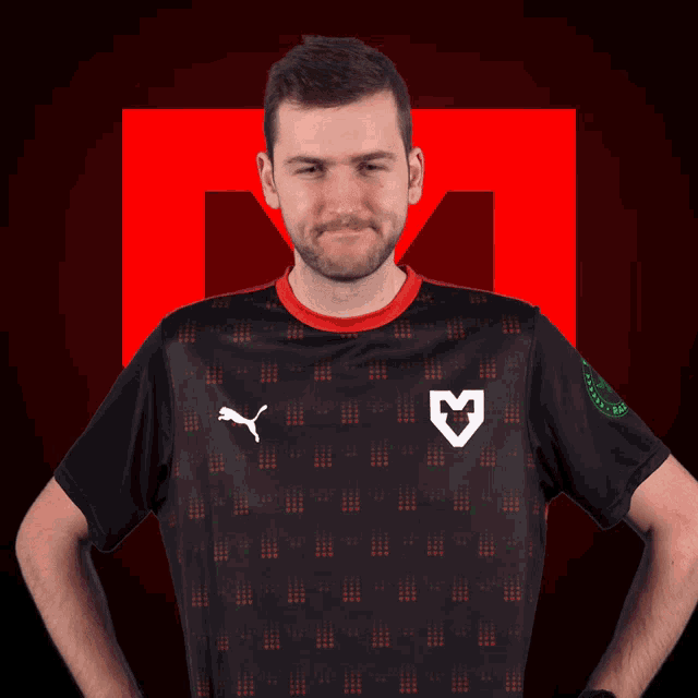 a man is wearing a black shirt with a white m on the front