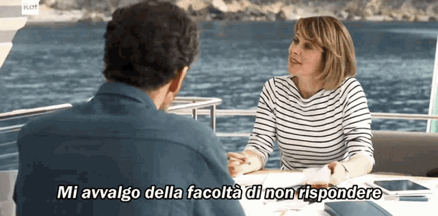 a man and a woman are sitting at a table with the words mi avvago della facolta di non rispondere