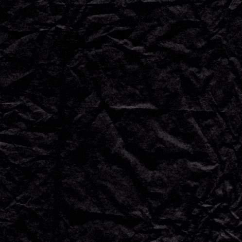 a piece of crumpled black paper with a cross in the middle