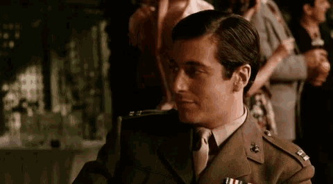 a man in a military uniform is sitting at a table with a woman .