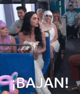 a woman in a wedding dress is sitting on a bus with other people and says bajan !
