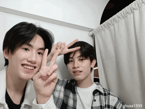 two young men are giving the peace sign and the name phuaa1599 is on the bottom