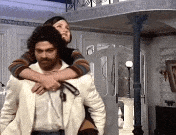 a man is carrying a woman on his back in a room