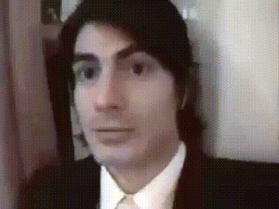 a man in a suit and tie is looking at the camera in a blurry photo