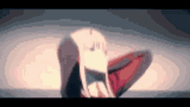 a blurred image of a girl with long white hair sitting on the ground .