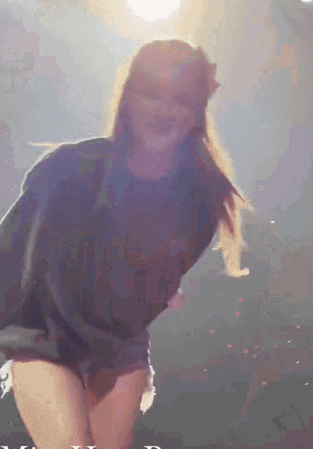 a woman in a black shirt is dancing on stage