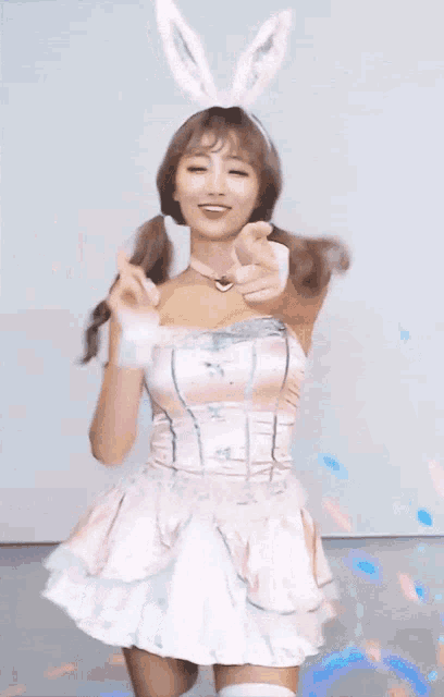 a woman in a pink dress and bunny ears dancing