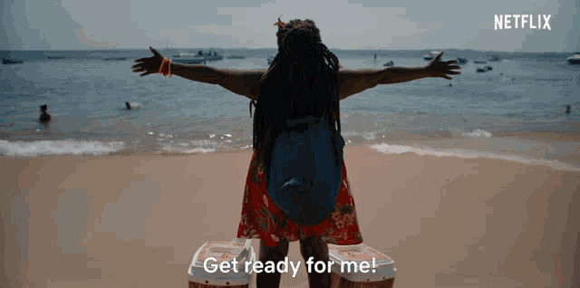 a woman stands on a beach with her arms outstretched and the words get ready for me