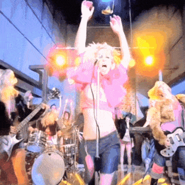 a woman singing into a microphone in front of a crowd of people