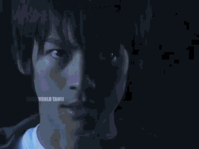 a person is standing in a dark forest with a blue light coming out of their hand .