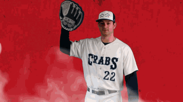 a baseball player for the crabs holds his glove up in the air