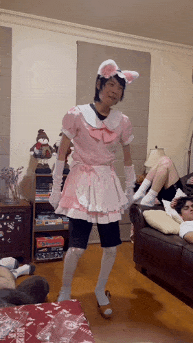 a man in a pink maid costume is standing in a living room