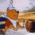 winnie the pooh is sitting at a table holding a spoon and a jar of honey .