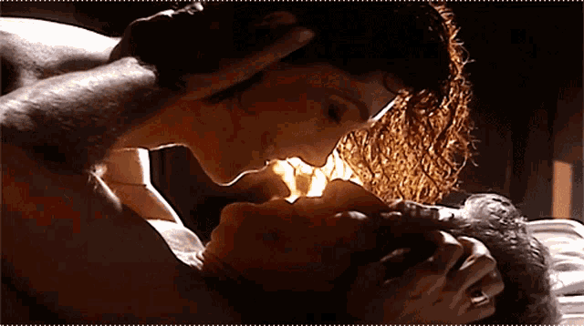 a man and a woman are kissing in the dark