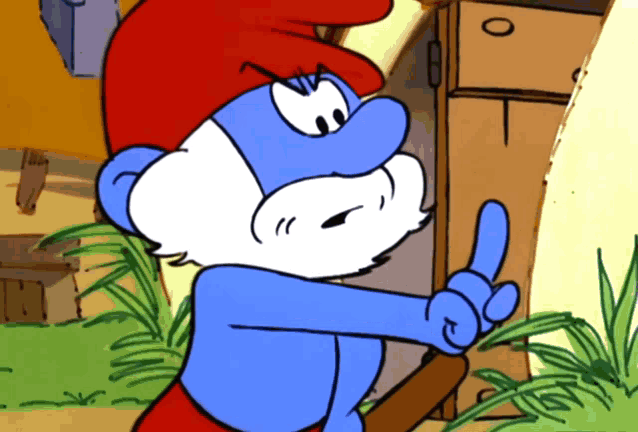 a smurf with a red hat and beard is giving a thumbs up