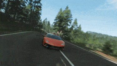 an orange lamborghini is driving down a road