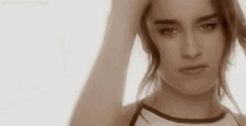 a close up of a woman holding her hair in her hand .
