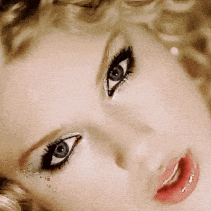 a close up of a woman 's face with blue eyes