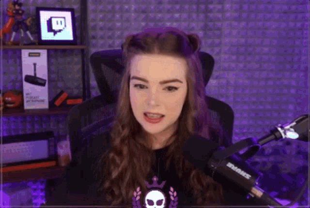 a young woman is sitting in front of a microphone in a room .