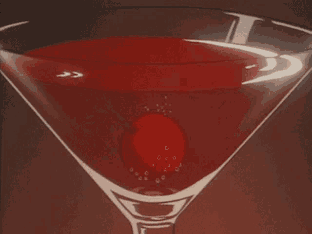 a martini with a cherry in it and bubbles