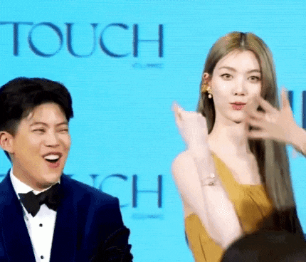 a man and a woman are standing next to each other in front of a blue background that says touch