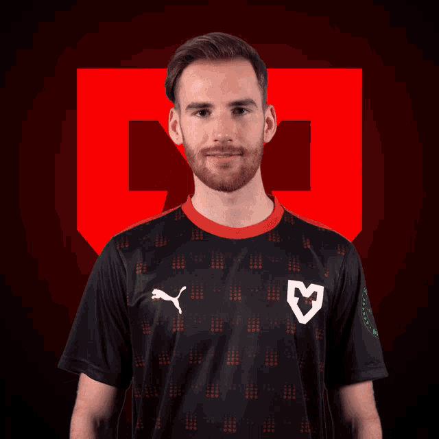 a man with a beard wears a black shirt with a puma logo on the front