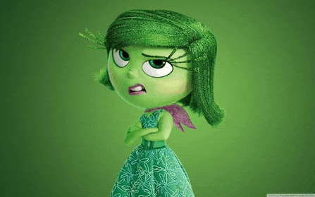 a green cartoon character with a purple scarf around her neck is standing with her arms crossed