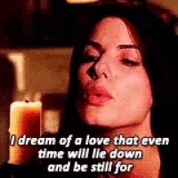 a woman is holding a candle in front of her face and saying i dream of a love