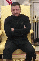 a man is sitting in a chair with his arms crossed