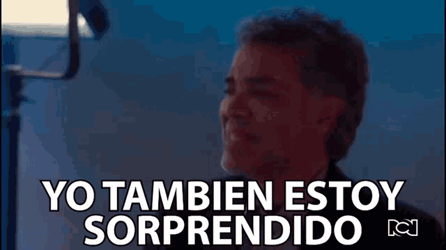 a man in a suit says yo tambien estoy sorprendido in front of a microphone