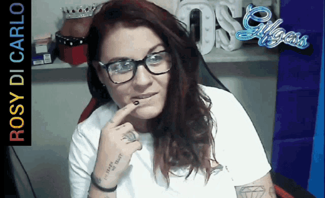 a woman wearing glasses has a tattoo on her wrist that says " i 'll never trust you "
