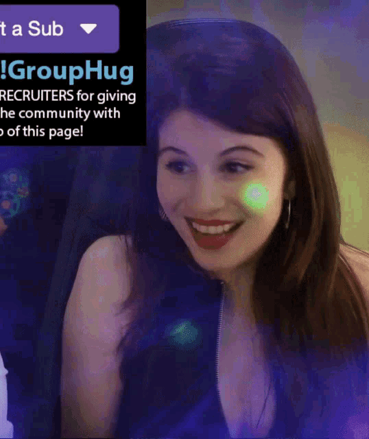 a woman is smiling in front of a sign that says grouphug recruiters for giving the community with a sub