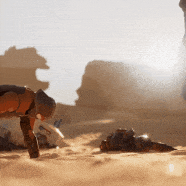 a person is kneeling down in the sand while another person is laying down