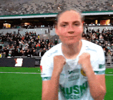 a female soccer player wearing a white shirt that says aussie on it