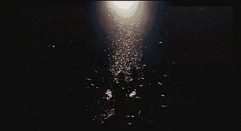 a person is standing in the dark with a light shining on them
