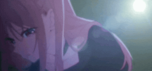 a close up of a girl with pink hair in a dark room with a light behind her .