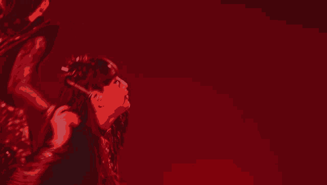 a woman in a red dress holds a red object