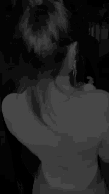 a black and white photo of a woman 's back and shoulder