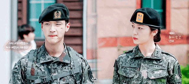 a man and a woman in military uniforms are standing next to each other in front of a building