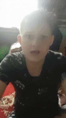 a young boy in a black shirt is sitting in front of a red table .