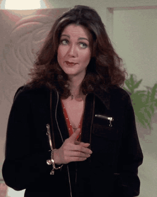 a woman wearing a black jacket and a bracelet on her wrist