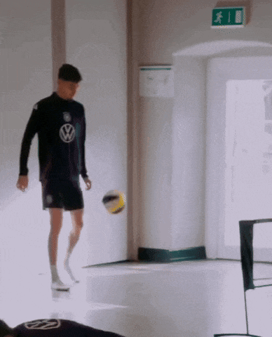 a man in a volkswagen shirt is kicking a ball